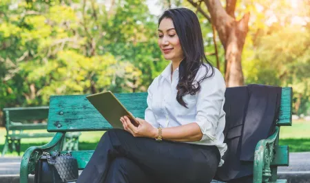 woman in park reading tablet