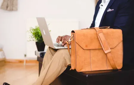 person on laptop with bag